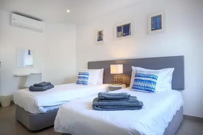 a bedroom with a bed with a blue blanket on it at Waterside 3 Bedroom Sea view in Luz