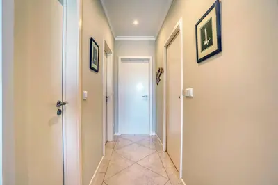 a hallway with a white door and a tile floor at Pérola - Madeira Inn Group in Funchal