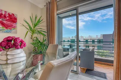 a dining room with a glass table and a window at Pérola - Madeira Inn Group in Funchal