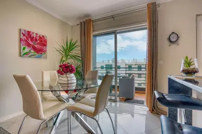 a dining room with a glass table and chairs at Pérola - Madeira Inn Group in Funchal
