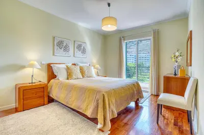 a bedroom with a bed and a window and a chair at Pérola - Madeira Inn Group in Funchal