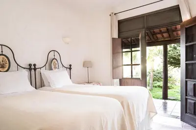 two beds in a bedroom with a window at Casas de Campo do Pomar B&B - Self Check-in in Santana