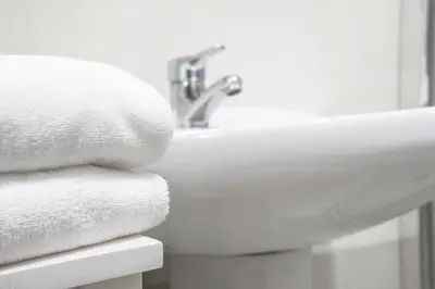a pile of towels sitting on a bathroom sink at Casas de Campo do Pomar B&B - Self Check-in in Santana