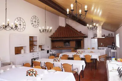 a room with tables and chairs and a kitchen at Casas de Campo do Pomar B&B - Self Check-in in Santana