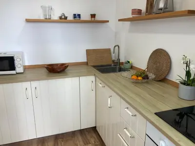a kitchen with white cabinets and a sink and a counter at Casa do Atlântico in Funchal