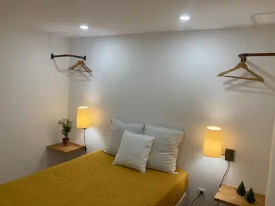 a bedroom with a yellow bed with two lamps at Casa do Atlântico in Funchal