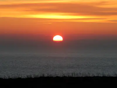 a sunset over the ocean with the sun in the sky at Monte de Santo Antonio - Turismo Rural in Vila do Bispo