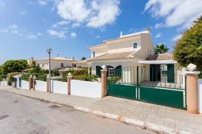 a white house with a green fence on a street at Villa Paraiso da Luz by Seewest in Luz