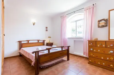 a bedroom with a bed and a dresser and a window at Villa Paraiso da Luz by Seewest in Luz