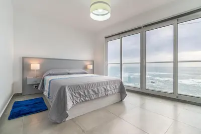a white bedroom with a bed and large windows at Casa das bonecas 2 # Private Garage Included # in Paul do Mar