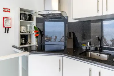 a kitchen with white cabinets and a sink and a window at Casa das bonecas 2 # Private Garage Included # in Paul do Mar