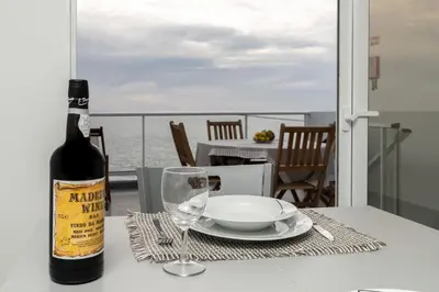 a bottle of wine sitting on a table with a glass at Casa das bonecas 2 # Private Garage Included # in Paul do Mar