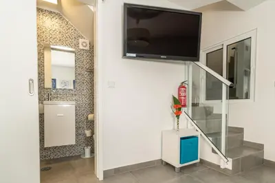 a living room with a flat screen tv on the wall at Casa das bonecas 2 # Private Garage Included # in Paul do Mar