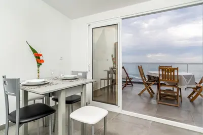a dining room with a table and a view of the ocean at Casa das bonecas 2 # Private Garage Included # in Paul do Mar
