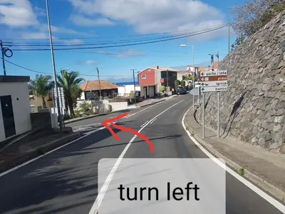 an empty street with a turn left sign on the road at Casa das bonecas 2 # Private Garage Included # in Paul do Mar