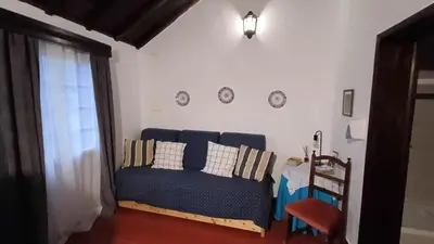 a living room with a blue couch and a table at Quinta do Monte Santo in Vila do Porto