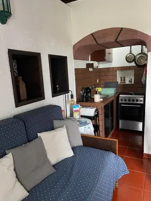 a living room with a blue couch and a kitchen at Quinta do Monte Santo in Vila do Porto