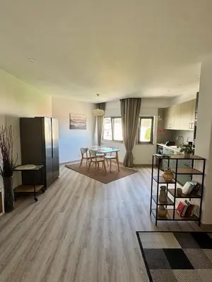 a living room with a table and a kitchen at Apartamentos Sol da Luz in Luz