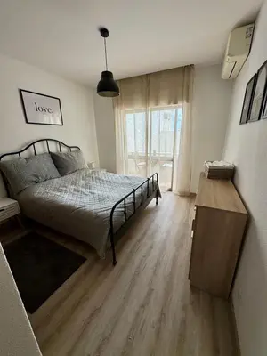 a bedroom with a bed and a wooden floor at Apartamentos Sol da Luz in Luz