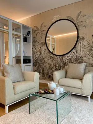 a living room with two couches and a mirror at VidaMar Resort Hotel Madeira in Funchal