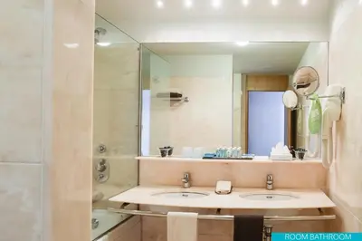 a bathroom with two sinks and a large mirror at VidaMar Resort Hotel Madeira in Funchal