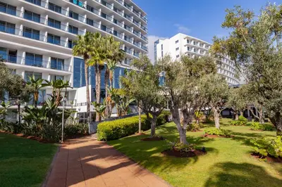a park in front of a building with trees and bushes at VidaMar Resort Hotel Madeira in Funchal