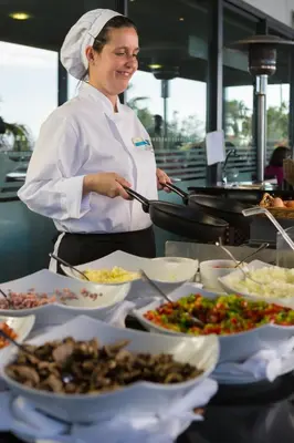 a chef standing in a kitchen preparing food at VidaMar Resort Hotel Madeira in Funchal