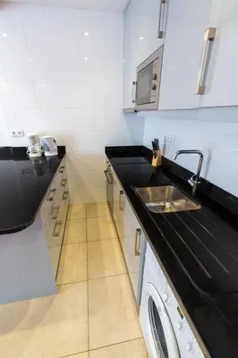 a kitchen with a black counter top and a sink at Sea Breeze I in Caniço