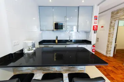 a kitchen with a black counter top and a sink at Sea Breeze I in Caniço