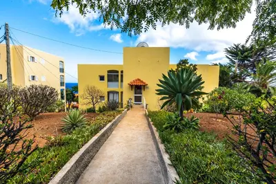 a yellow house with a pathway in front of it at Sea Breeze I in Caniço