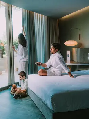 a woman drawing on a bed with two little girls at The Views Oasis in Caniço