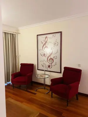 a room with two red chairs and a picture on the wall at Estalagem do Vale in São Vicente