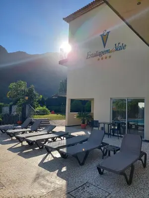 a row of lounge chairs in front of a building at Estalagem do Vale in São Vicente