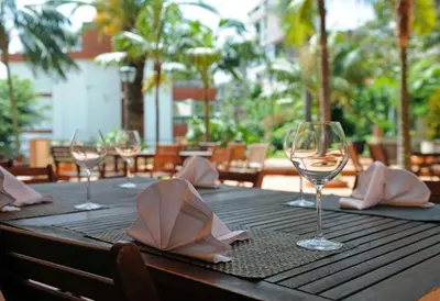 a wooden table with wine glasses and napkins on it at Florasol Residence Hotel - Dorisol hotels in Funchal