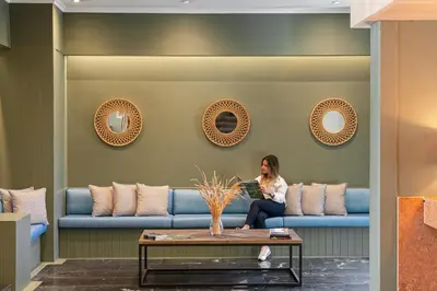 a woman sitting on a couch in a living room at Dorisol Buganvilia Studio Hotel in Funchal