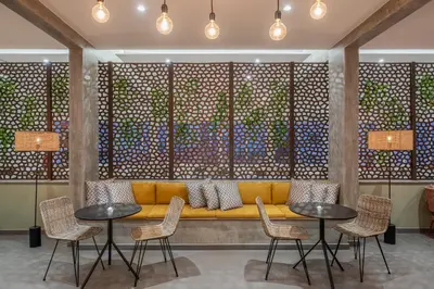 a yellow couch in a room with tables and chairs at Dorisol Buganvilia Studio Hotel in Funchal