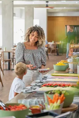 a woman standing next to a table with food at Dorisol Buganvilia Studio Hotel in Funchal