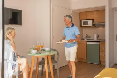 an older man holding a plate of food in a kitchen at Dorisol Buganvilia Studio Hotel in Funchal