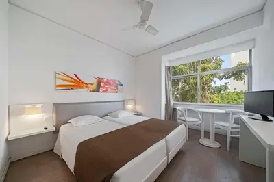 a bedroom with a bed and a table and a window at Dorisol Estrelicia Hotel in Funchal