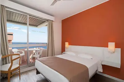 a hotel room with a bed and a balcony at Dorisol Estrelicia Hotel in Funchal
