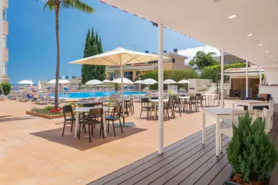 a patio with tables and chairs and a swimming pool at Dorisol Estrelicia Hotel in Funchal