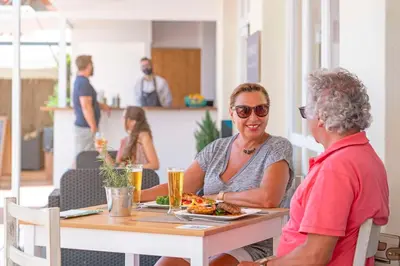 two women sitting at a table with a plate of food at Dorisol Estrelicia Hotel in Funchal