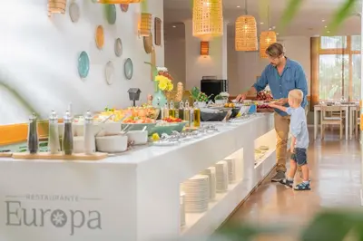 a man and a child standing in front of a buffet at Dorisol Estrelicia Hotel in Funchal
