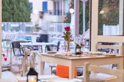 a table with a rose in a vase on it on a patio at Dorisol Estrelicia Hotel in Funchal