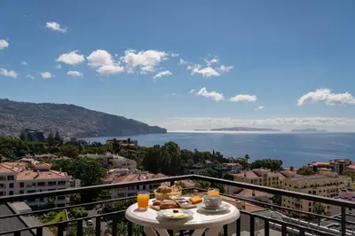 a table with food on a balcony overlooking the water at Dorisol Mimosa Studio Hotel in Funchal