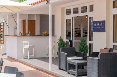 a patio with chairs and a bar in a building at Dorisol Mimosa Studio Hotel in Funchal