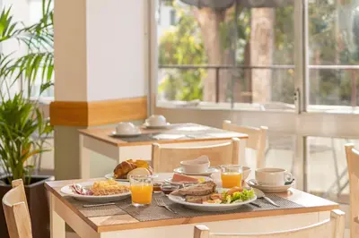 a table with plates of food and glasses of orange juice at Dorisol Mimosa Studio Hotel in Funchal