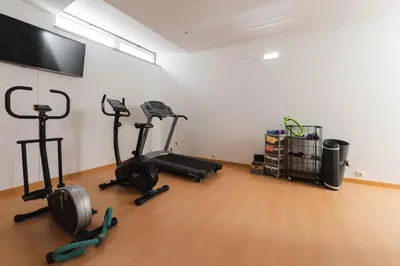 a gym with exercise bikes and a flat screen tv at Solar de Mos in Lagos