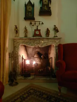 a living room with a fireplace with a clock above it at Solar de Mos in Lagos