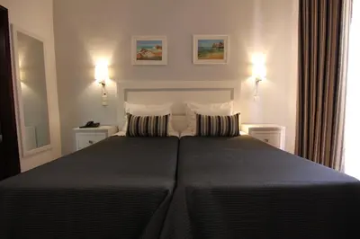 a bedroom with a large bed with two pillows at Solar de Mos in Lagos